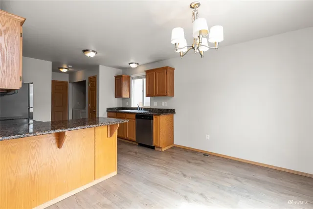 a kitchen with stainless steel appliances granite countertop a sink a stove top oven a counter space and cabinets