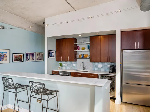 a kitchen with stainless steel appliances granite countertop a refrigerator and a stove top oven