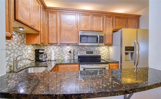 a kitchen with wooden cabinets a refrigerator and a sink