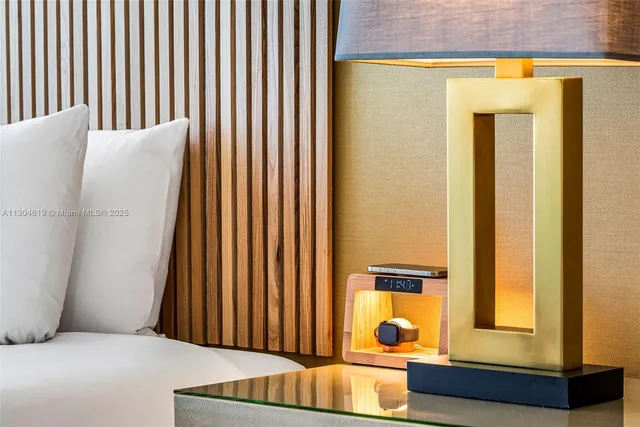 a bedroom with a bed a lamp and a large window