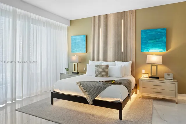 a bedroom with a bed couch and a flat tv screen next to a window