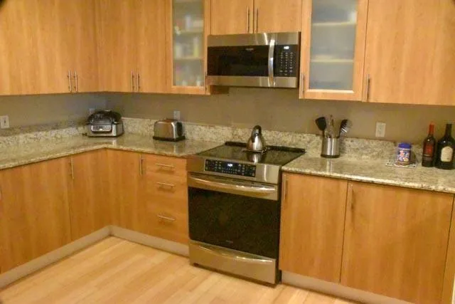 a kitchen with stainless steel appliances granite countertop a sink stove and microwave