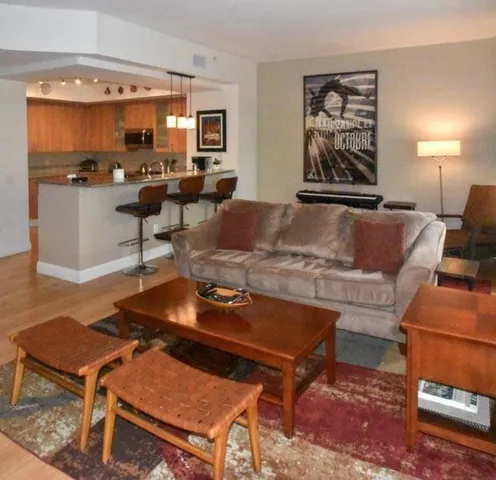 a living room with furniture a rug and a lamp