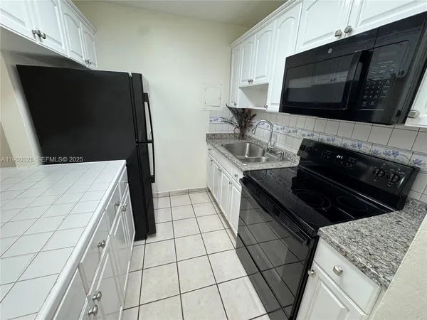 a kitchen with stainless steel appliances a stove microwave and sink