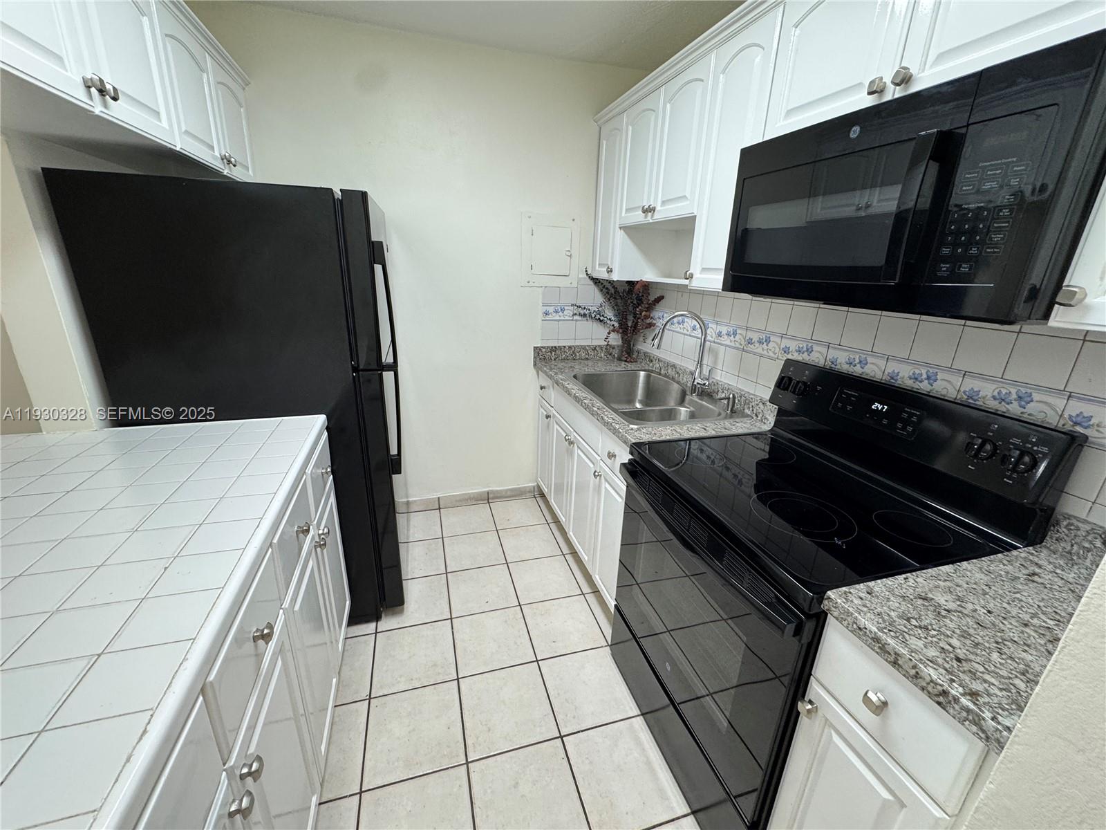 677 Southwest 9th Avenue, Unit 212 Miami, FL 33130 - Photo 2 of 19 a kitchen with stainless steel appliances a stove microwave and sink