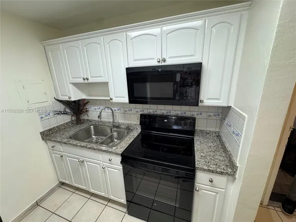 a kitchen with stainless steel appliances granite countertop a sink stove and microwave