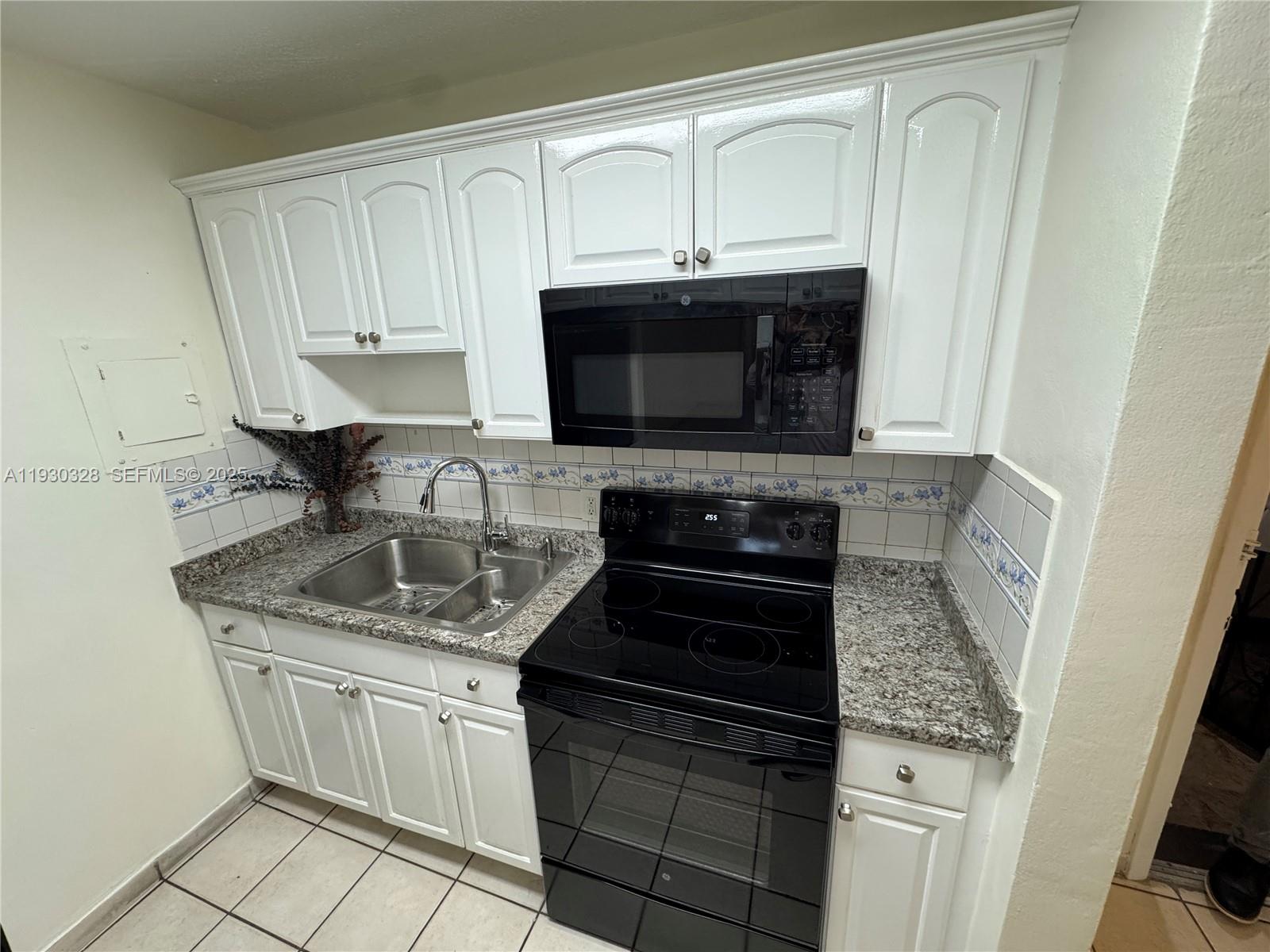 677 Southwest 9th Avenue, Unit 212 Miami, FL 33130 - Photo 3 of 19 a kitchen with stainless steel appliances granite countertop a sink stove and microwave