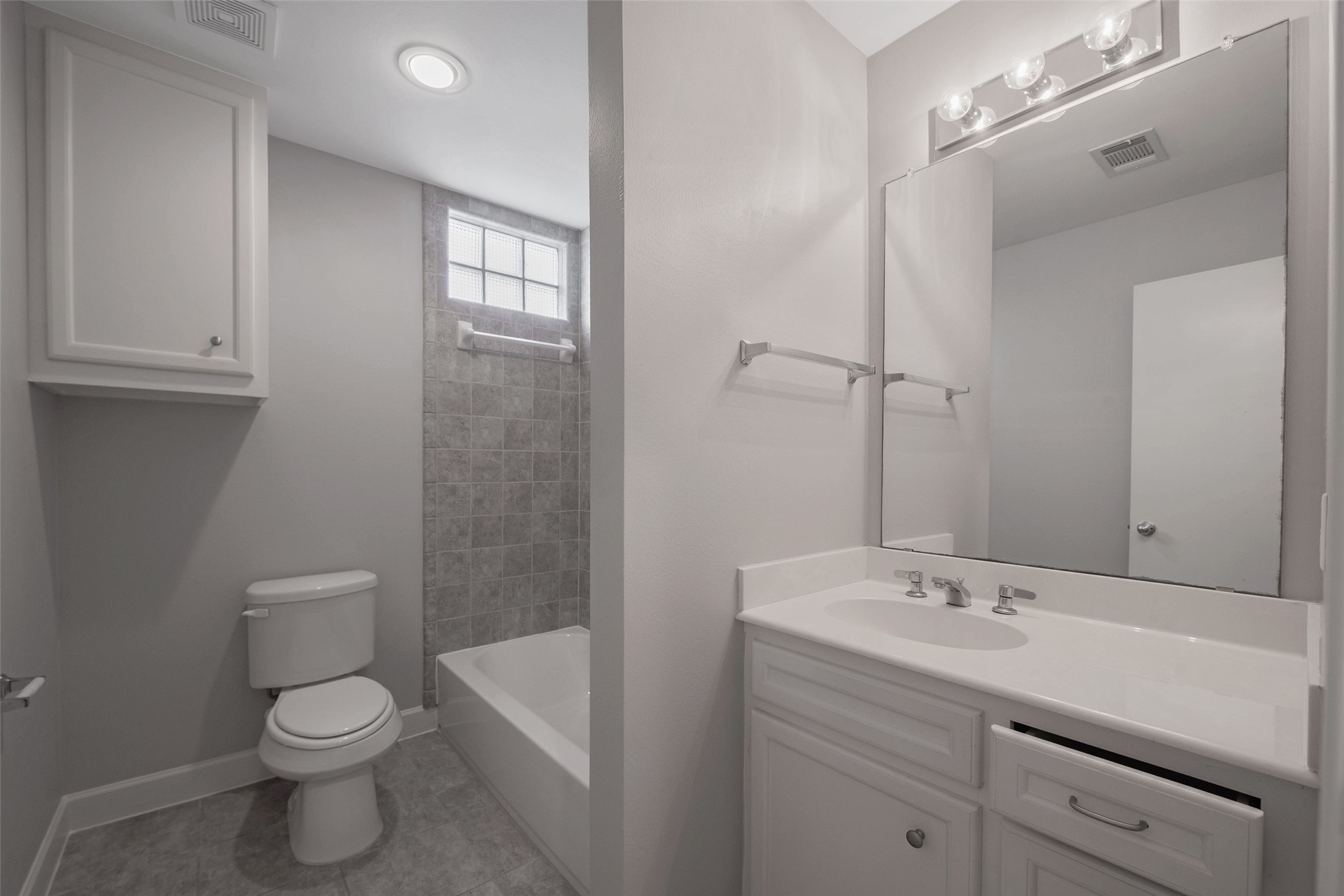 7650 Springhill Street, Unit 603 Houston, TX 77021 - Photo 12 of 26 a bathroom with a toilet a sink a mirror a bathtub and shower