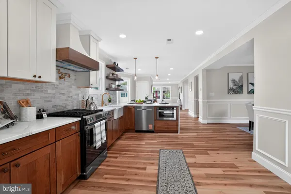 a large kitchen with stainless steel appliances granite countertop a stove and a sink