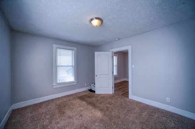 an empty room with closet and windows