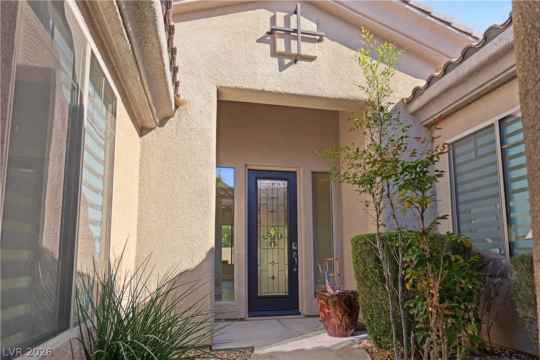 6 Mohansic Road Henderson, NV 89052 - Photo 5 of 38 A stucco entry alcove frames the decorative glass front door leading into the home.