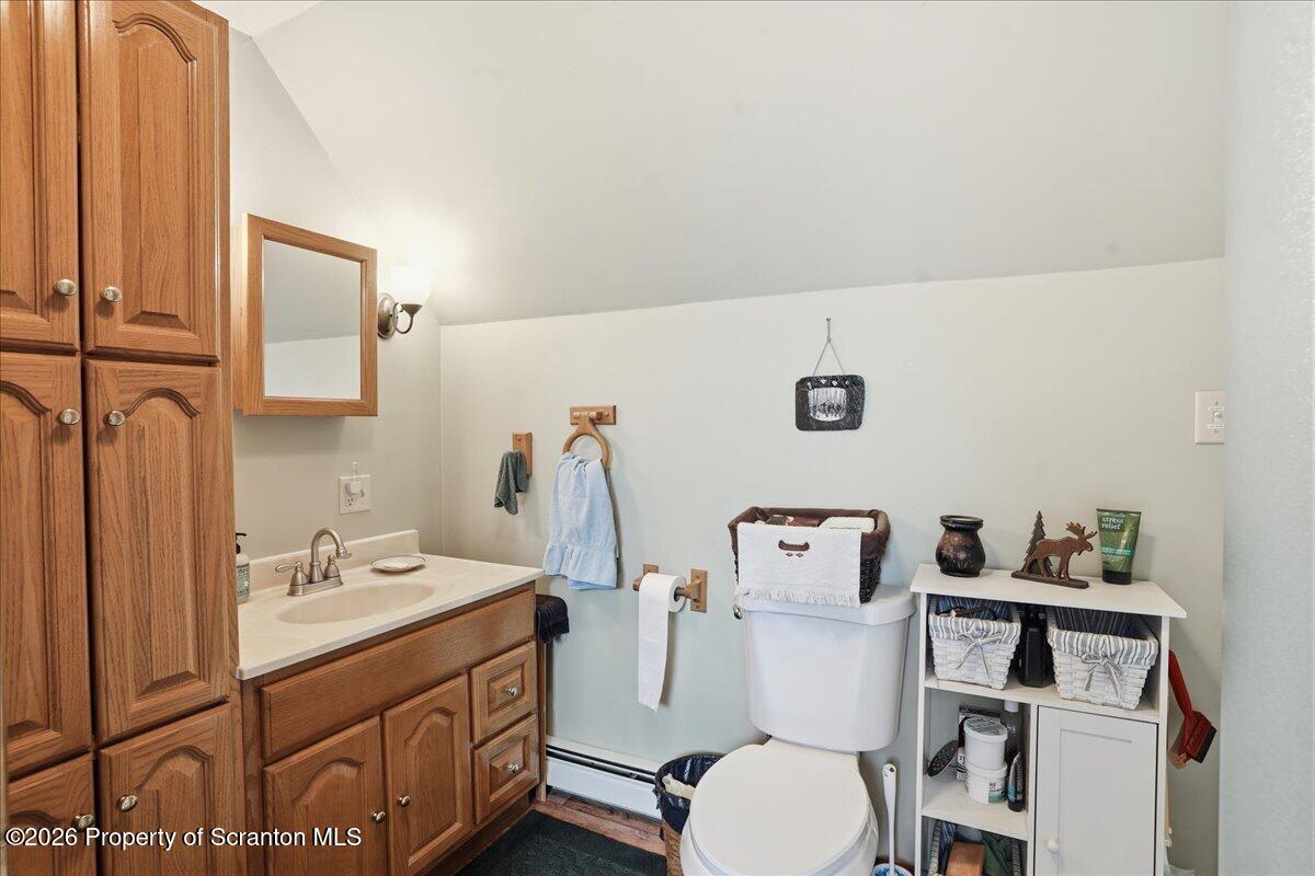 5231 Fiddle Lake Road Thompson, PA 18465 - Photo 18 of 34 a bathroom with a toilet sink and mirror