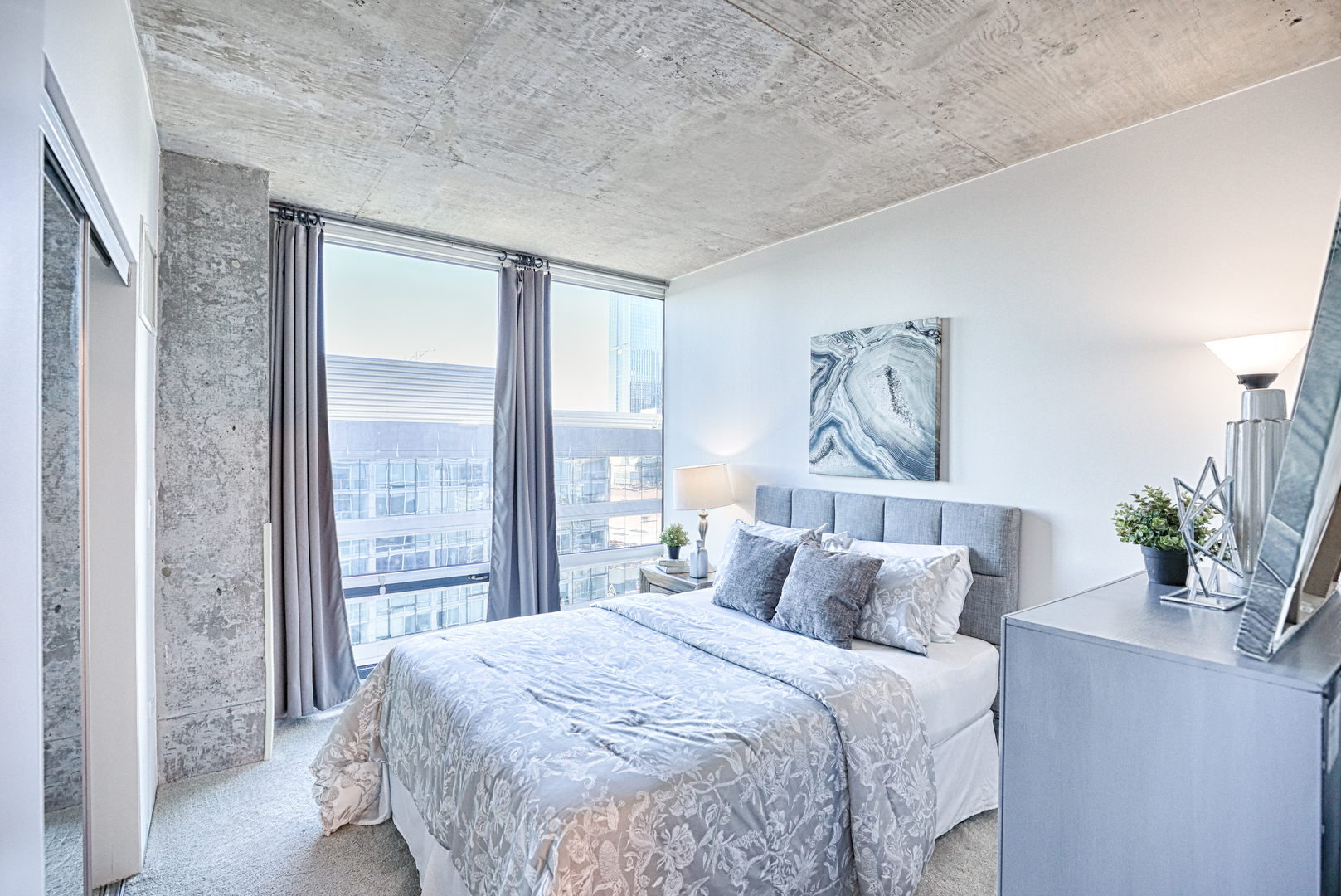 611 South Wells Street, Unit 1507 Chicago, IL 60607 - Photo 14 of 20 a bedroom with a large bed and a potted plant