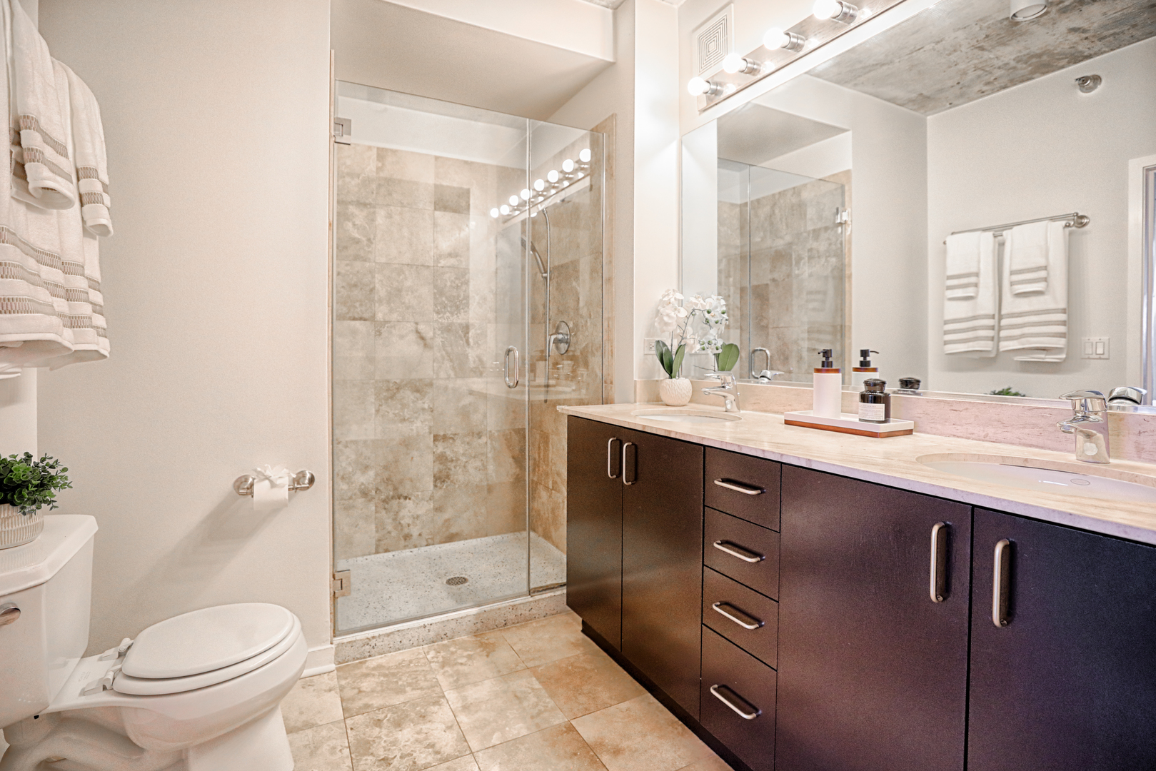 611 South Wells Street, Unit 1507 Chicago, IL 60607 - Photo 15 of 20 a bathroom with a double vanity sink toilet and shower