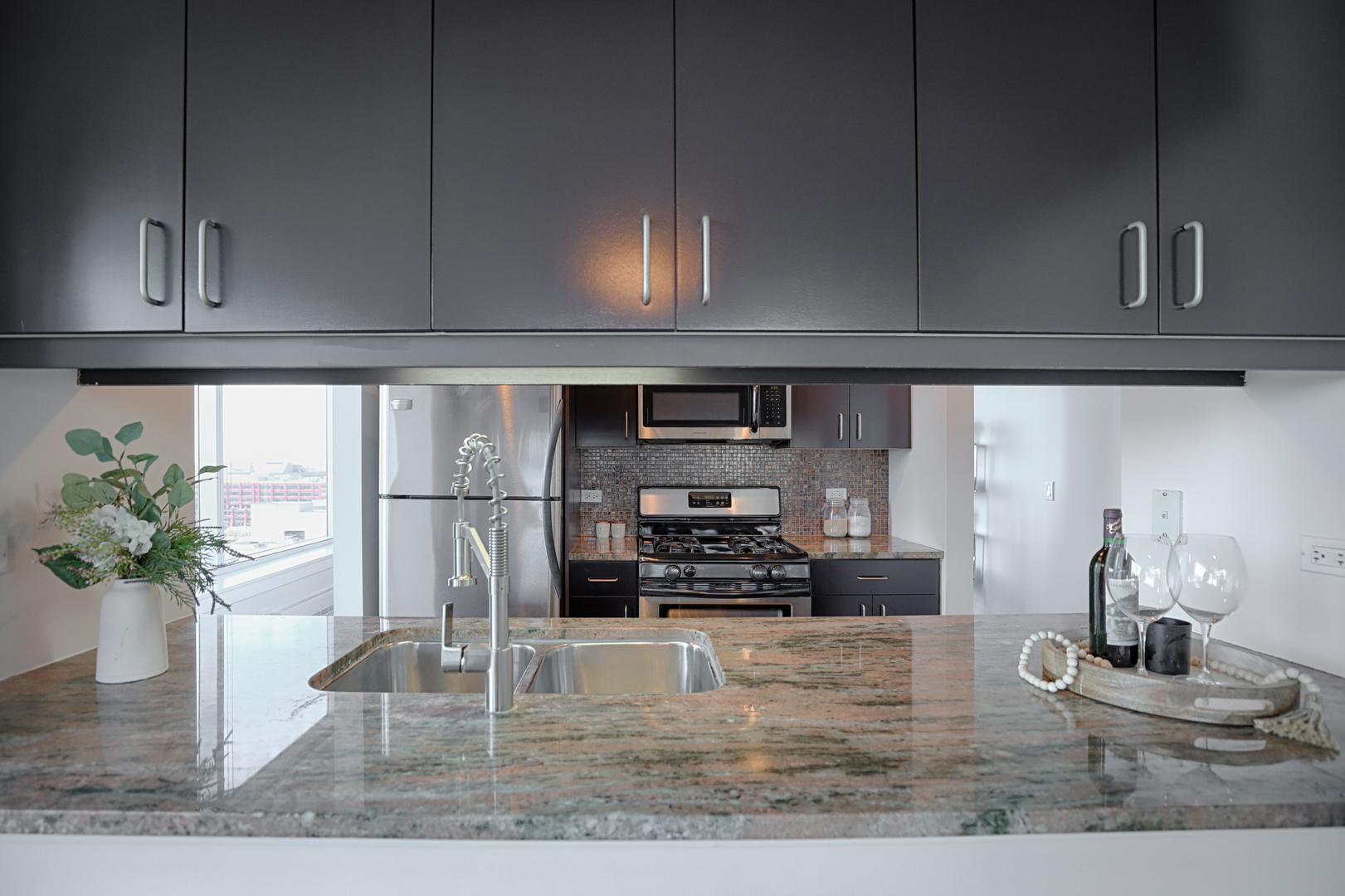 611 South Wells Street, Unit 1507 Chicago, IL 60607 - Photo 7 of 20 a kitchen with stainless steel appliances granite countertop a sink a stove and cabinets