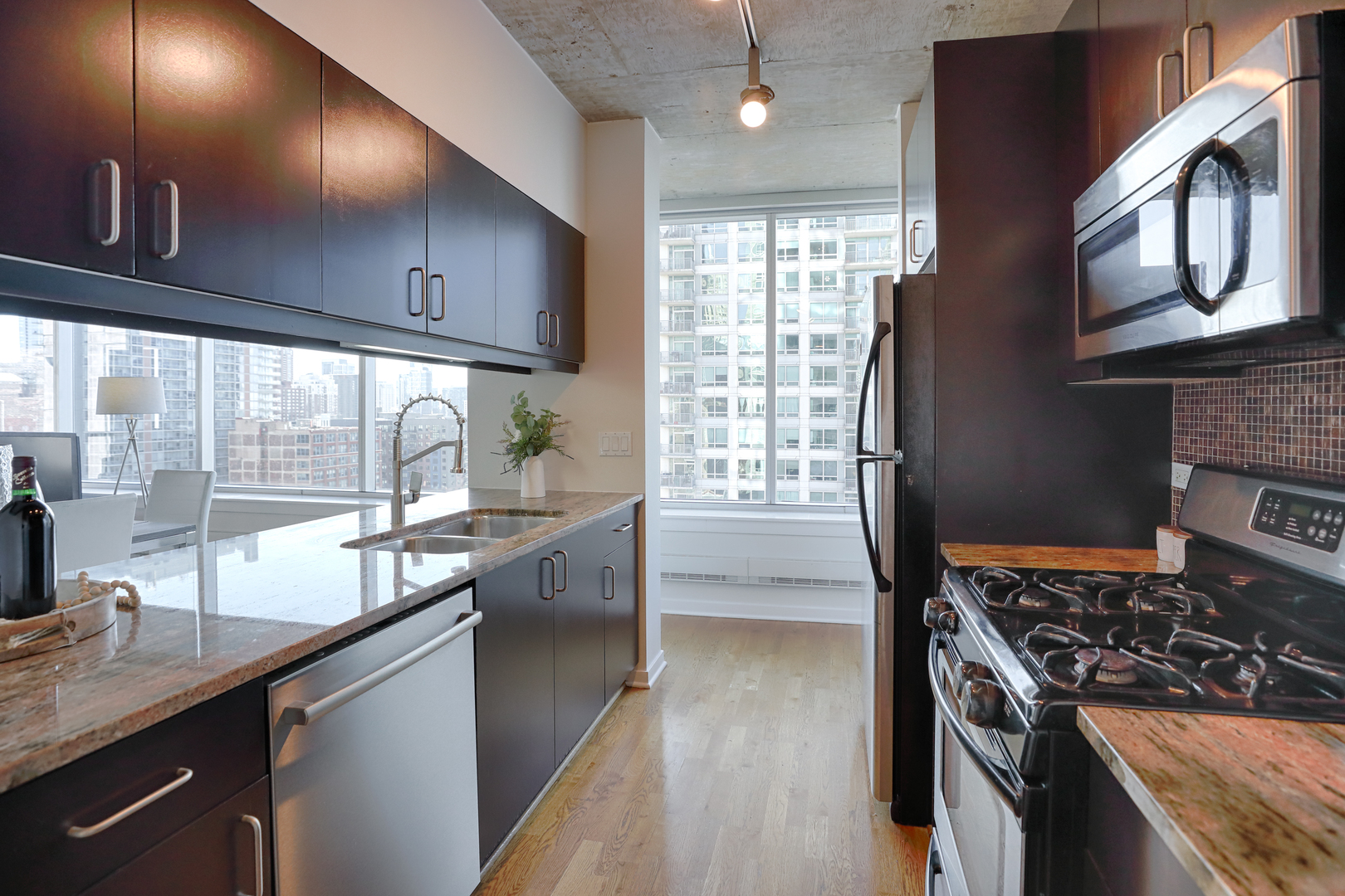 611 South Wells Street, Unit 1507 Chicago, IL 60607 - Photo 8 of 20 a kitchen with stainless steel appliances granite countertop a stove a sink and a refrigerator