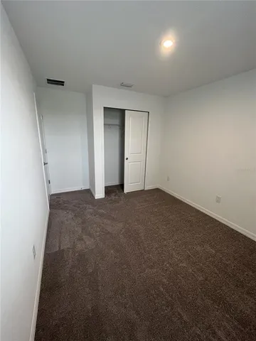 an empty room with closet and windows