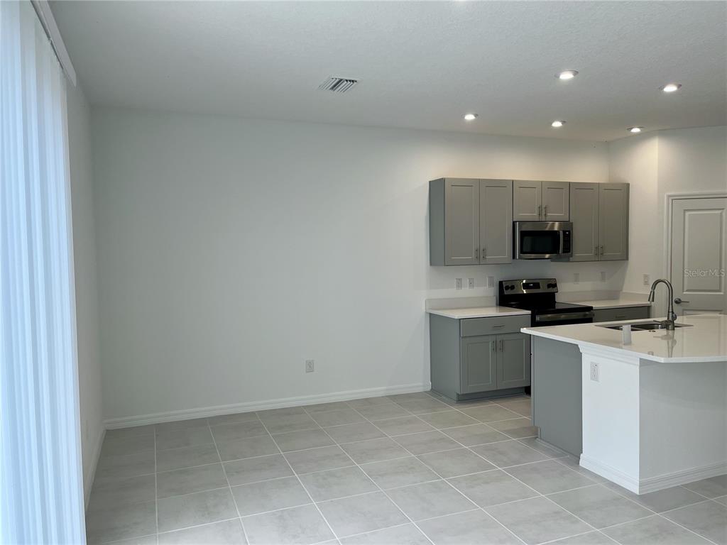 34142 Polacca Lane Wesley Chapel, FL 33543 - Photo 5 of 30 a kitchen with a sink a stove and cabinets