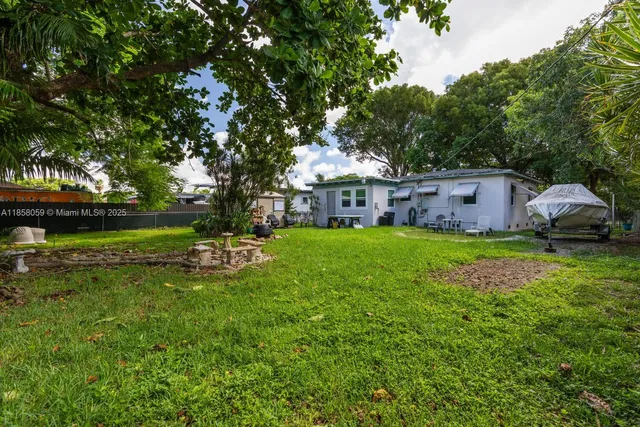 a view of a house with a big yard and sitting area