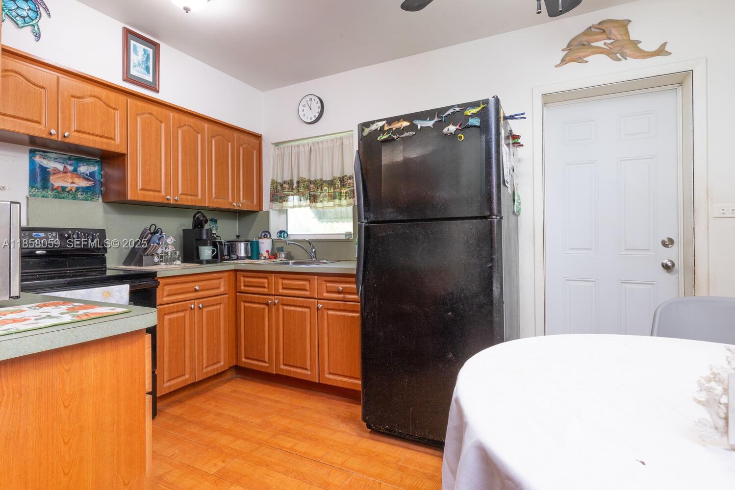 846 Northwest 3rd Avenue Homestead, FL 33030 - Photo 2 of 13 a kitchen with a refrigerator a stove top oven a sink and dishwasher with wooden floor
