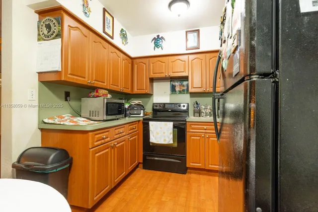 a kitchen with stainless steel appliances granite countertop a refrigerator a stove and a sink with wooden floor