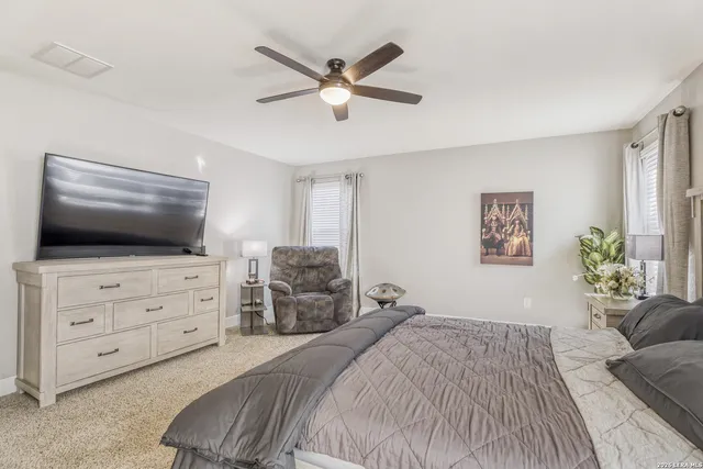 a bedroom with a large bed and a flat screen tv
