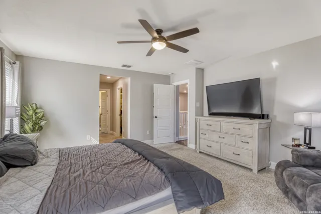 a bedroom with a large bed and a flat screen tv