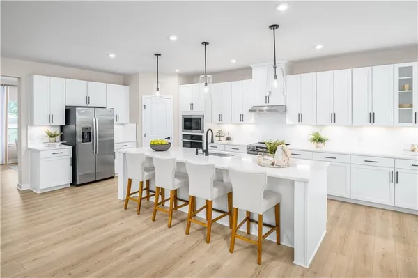 a kitchen with stainless steel appliances white cabinets and wooden floors