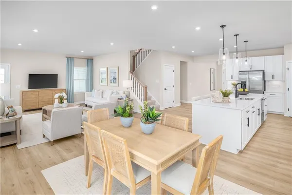 a kitchen with kitchen island white cabinets and stainless steel appliances
