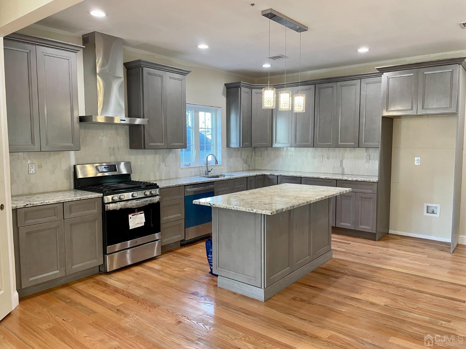 125 Ridge Road Colonia, NJ 07067 - Photo 3 of 26 a kitchen with stainless steel appliances granite countertop a stove a sink and a refrigerator