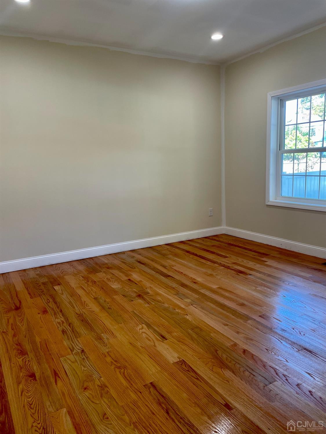 125 Ridge Road Colonia, NJ 07067 - Photo 10 of 26 an empty room with wooden floor and windows