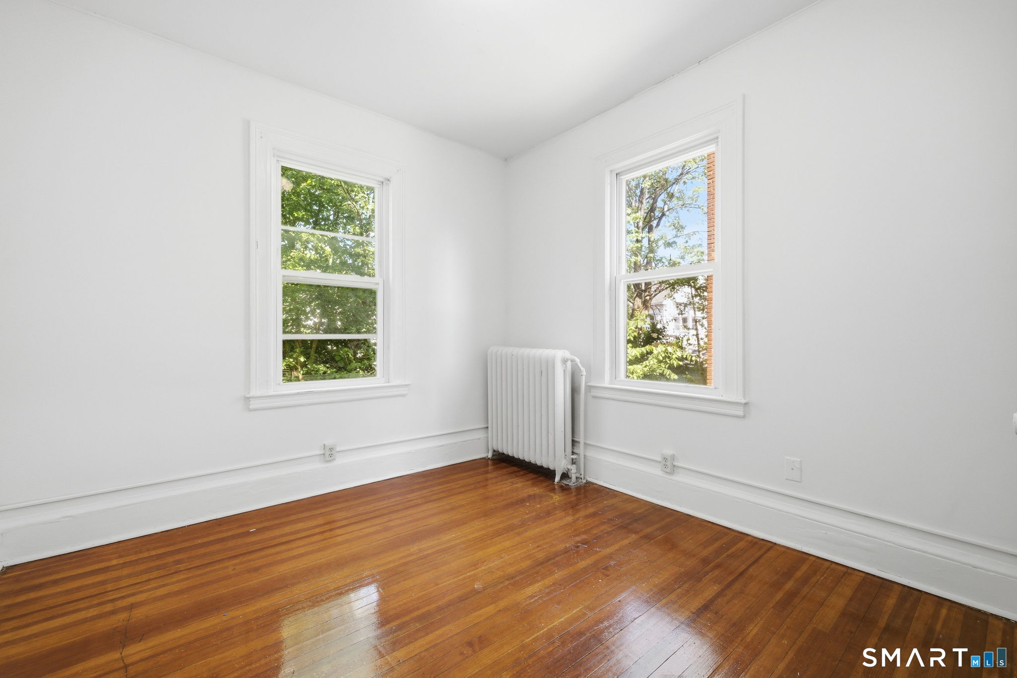 115 Baltimore Street, Unit 2 Hartford, CT 06112 - Photo 10 of 14 an empty room with wooden floor and windows