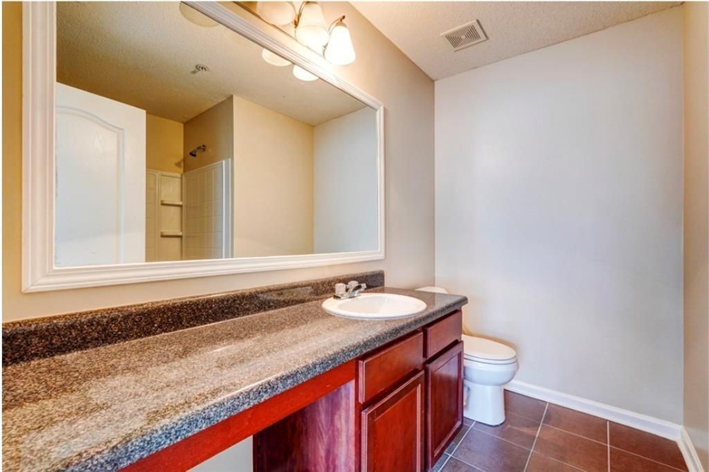 2837 Laurel Ridge Circle Atlanta, GA 30344 - Photo 19 of 20 a bathroom with a granite countertop sink and a mirror with toilet