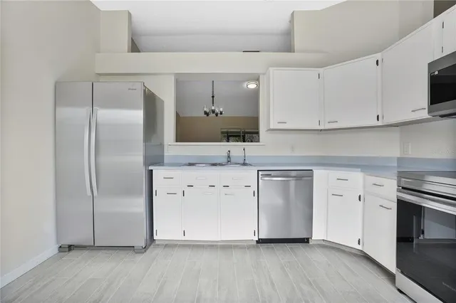 a kitchen with stainless steel appliances a refrigerator sink and cabinets