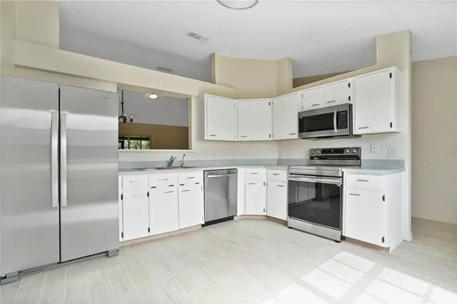 a kitchen with granite countertop a refrigerator stove and microwave