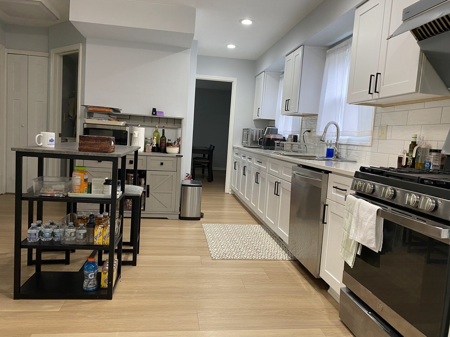 1408 Killdeer Drive Naperville, IL 60565 - Photo 5 of 43 a kitchen with stainless steel appliances a stove top oven a sink dishwasher and a dining table with wooden floor