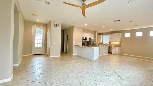 a view of a electric appliances in kitchen and empty room with windows