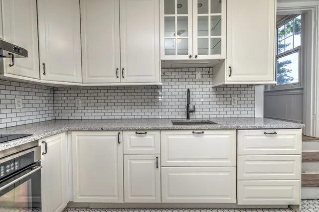 a kitchen with granite countertop a sink and a stove