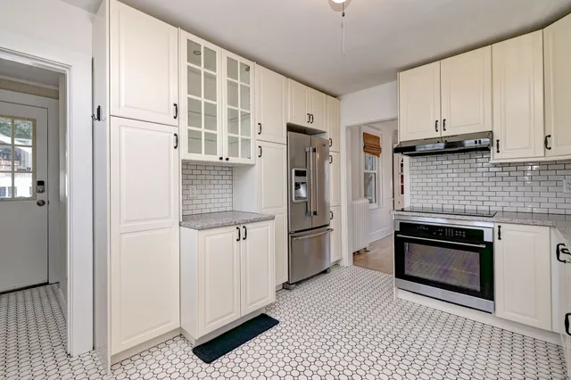 a kitchen with stainless steel appliances granite countertop a refrigerator and a stove top oven