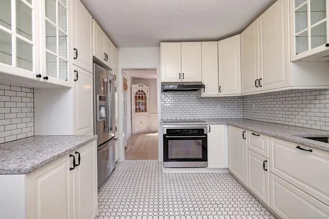 a kitchen with stainless steel appliances granite countertop a stove a sink and a refrigerator