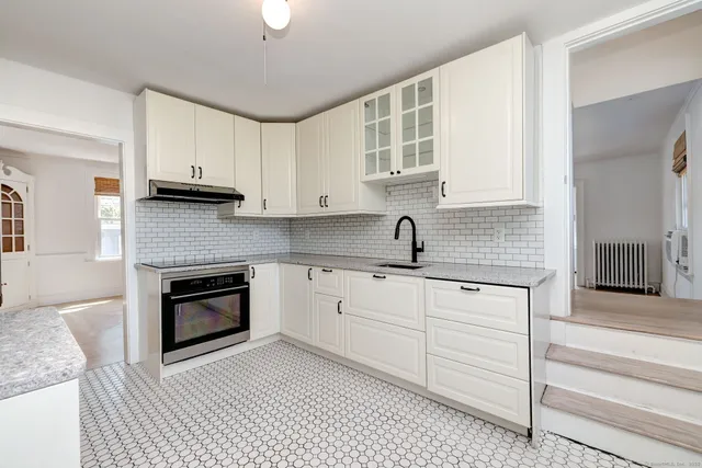 a kitchen with granite countertop a stove sink and cabinets