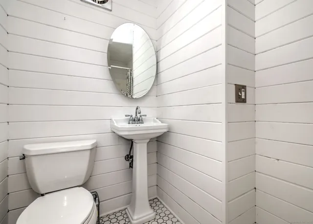 a bathroom with a toilet sink and mirror