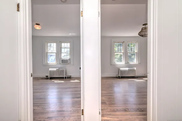 a view of a bedroom with wooden floor and a floor to ceiling window