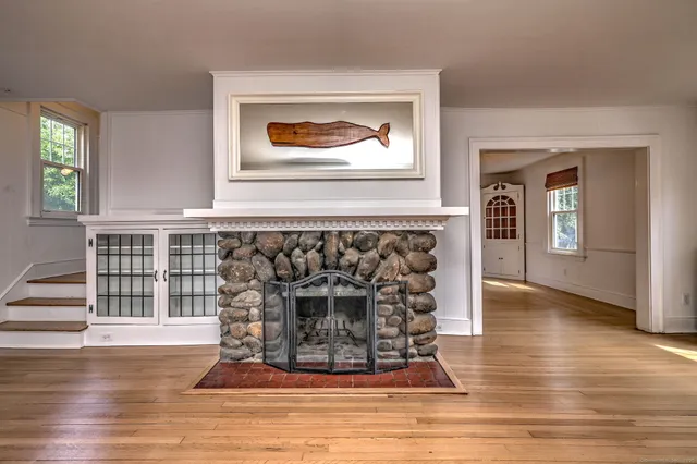 a living room with wooden floor and a fireplace
