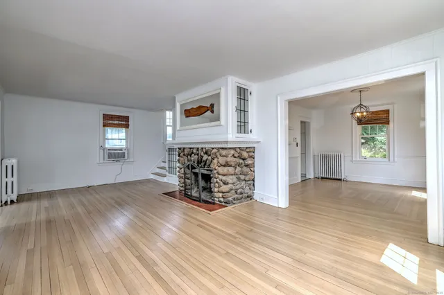 an empty room with wooden floor and a window