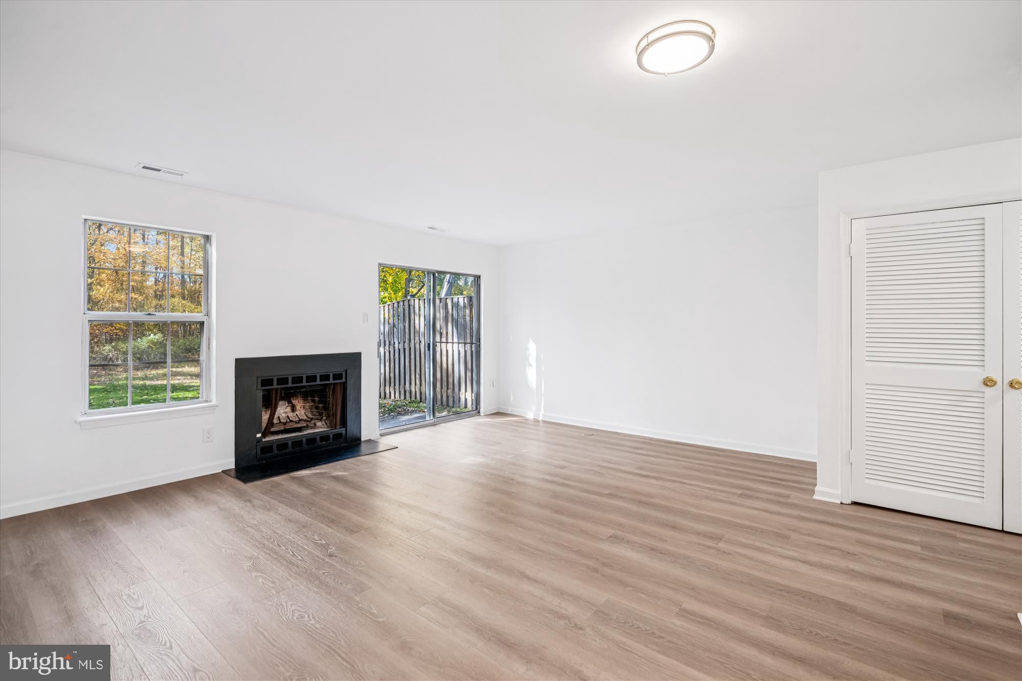 986 Breakwater Drive Annapolis, MD 21403 - Photo 7 of 31 an empty room with wooden floor fireplace and windows