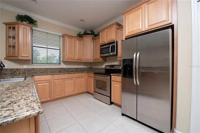 a kitchen with stainless steel appliances granite countertop a refrigerator and a stove top oven