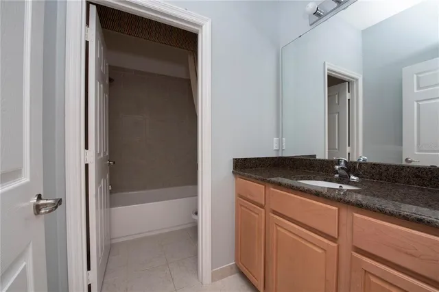 a bathroom with a granite countertop sink and mirror