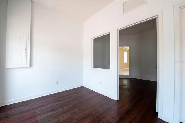 an empty room with wooden floor and closet