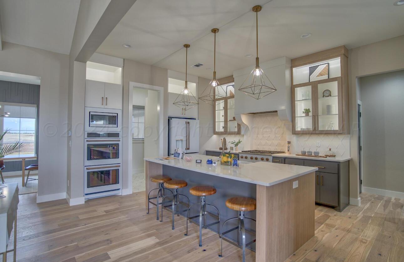 19181 Buck Springs Road Amarillo, TX 79119 - Photo 29 of 86 a kitchen with a sink stove and wooden floor